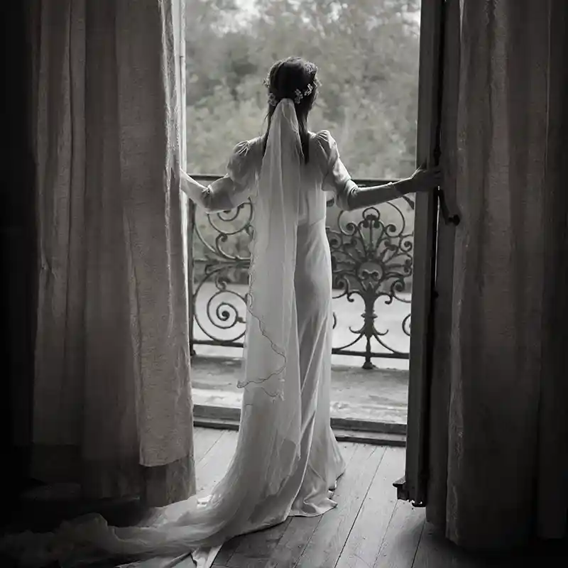 eine Braut im Brautkleid schaut in die Landschaft