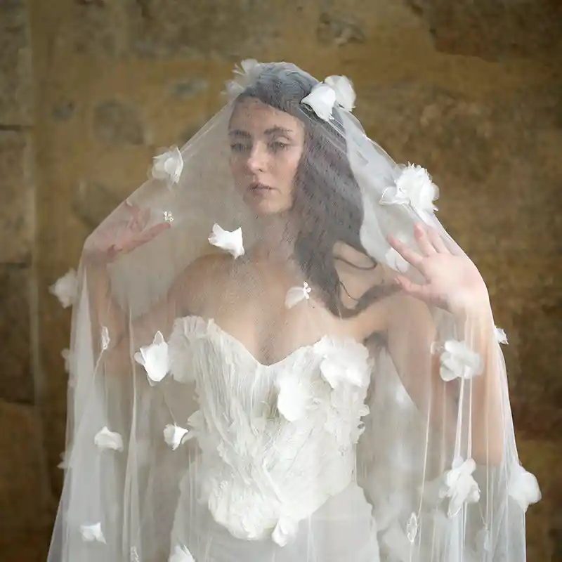 eine Braut im Brautkleid hinter einem Schleier