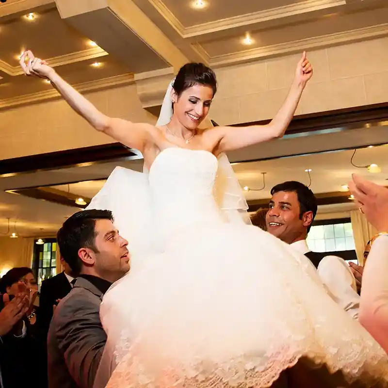 Braut wird mit den Händen hochgehoben.