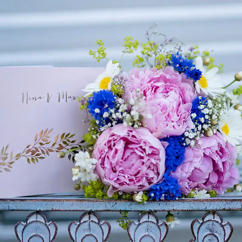 Blumen und Einladungskarte einer Hochzeit