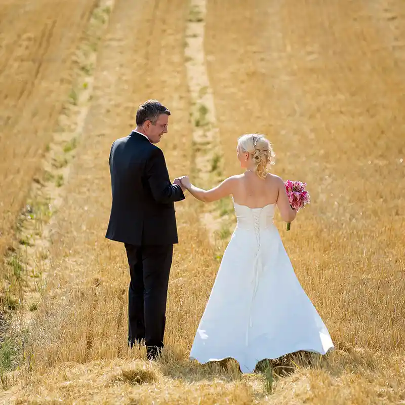 ein Brautpaar auf einem Weizenfeld