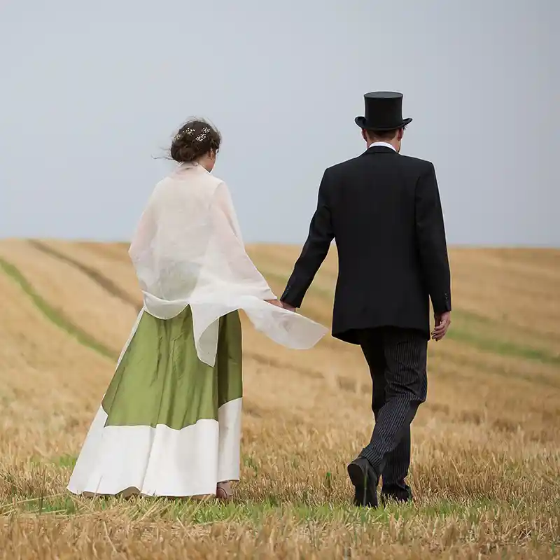 ein Brautpaar schreitet über ein abgemähtes Feld