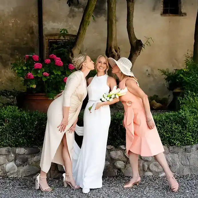 eine Braut wird von Mutter und Schwester geküsst