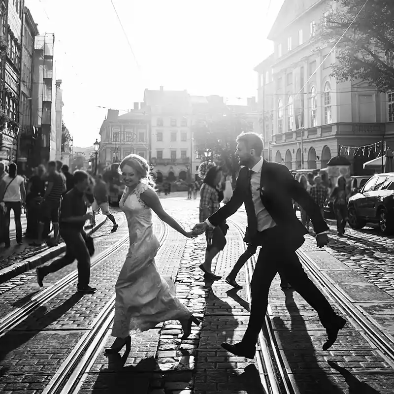 Ein Brautpaar schreitet über die belebte Straße in schwarz-weiss